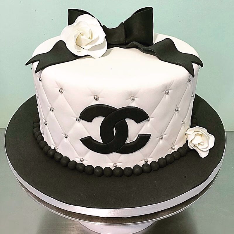 A sophisticated black and white themed cake, possibly with geometric patterns or floral designs.