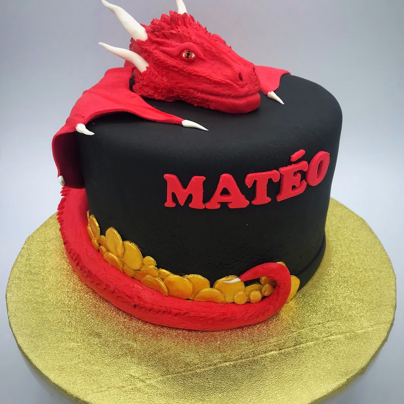 An impressive birthday cake shaped like or decorated with a dragon, possibly in vibrant colors.