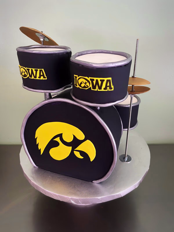 A highly detailed cake shaped like a drum, representing the Iowa Hawkeyes sports team.
