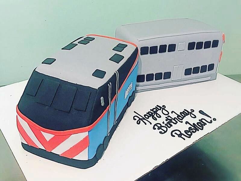 A novelty cake designed to resemble a Metra commuter train, likely for a train enthusiast.