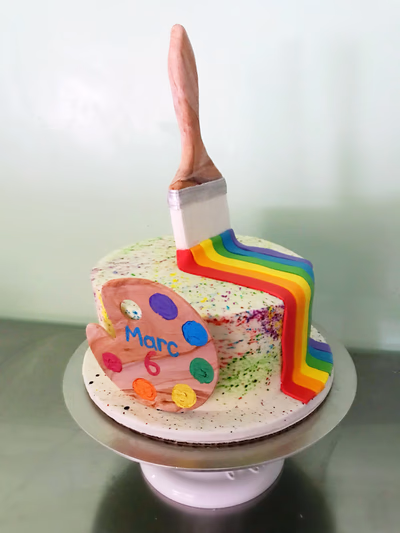An artistic cake designed to resemble a painting or an artist's palette, with colorful icing.