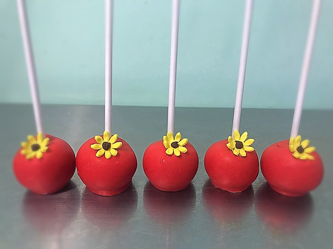 Red Cake pops with yellow flowers.