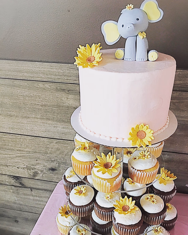 A charming baby shower cake adorned with cute elephant decorations.
