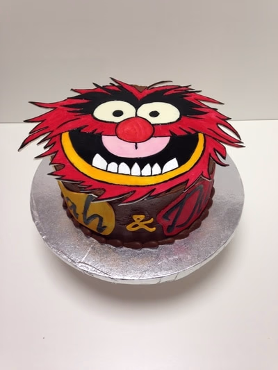A cake featuring a monster character from The Muppets, likely Cookie Monster or Animal.