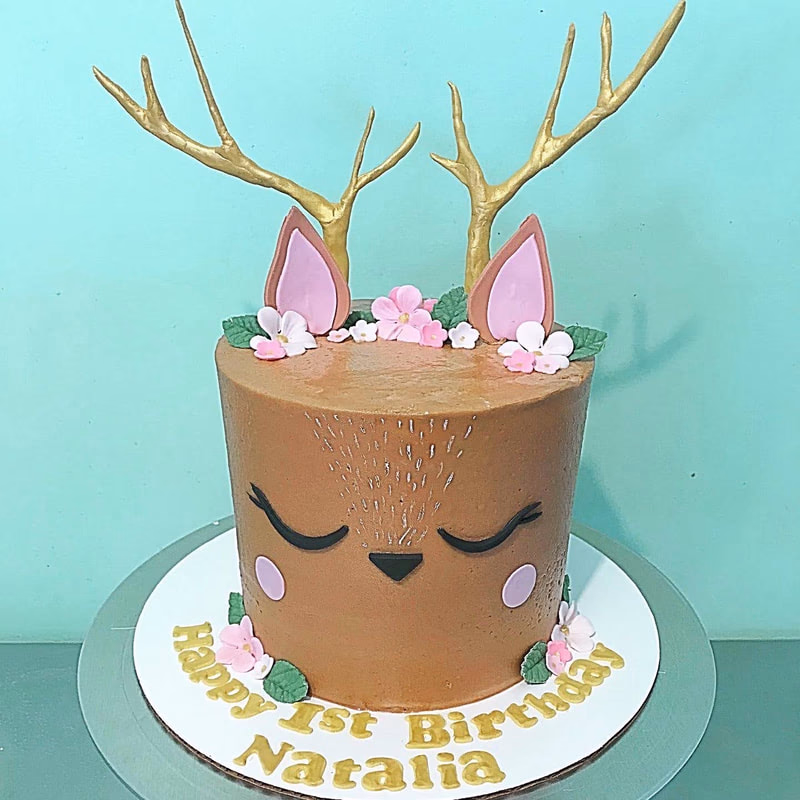 A cute cake with a deer theme, possibly for a baby shower or nature lover.