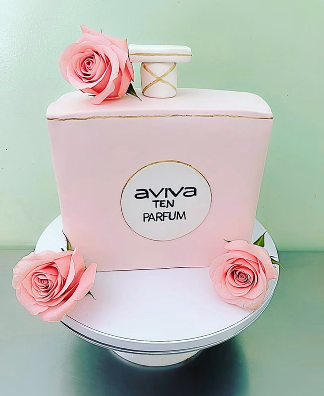 A stylish cake shaped and decorated to look like a perfume bottle, possibly for a fashion enthusiast.
