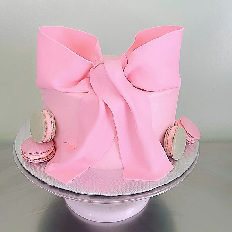 A charming cake adorned with a pink bow, suitable for a feminine celebration.