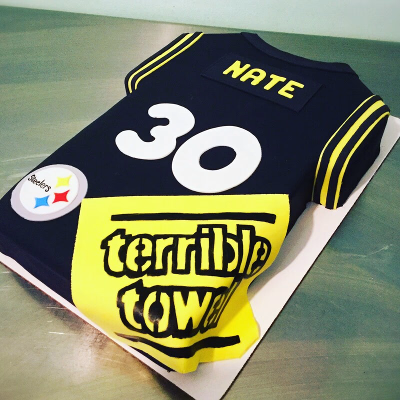 A cake celebrating the Pittsburgh Steelers football team, adorned with team colors and logos.